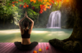 A white woman lifting her arms in a yoga pose, while sitting on a pink dock, in front of a small waterfall and pond.